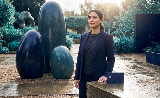 A person considers a measured payment path beside smooth stone forms while reviewing credit card payment allocation.