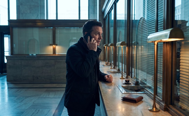 A person confirms the resolution of a credit card overpayment on a blank phone in a bright city-hall service lobby.