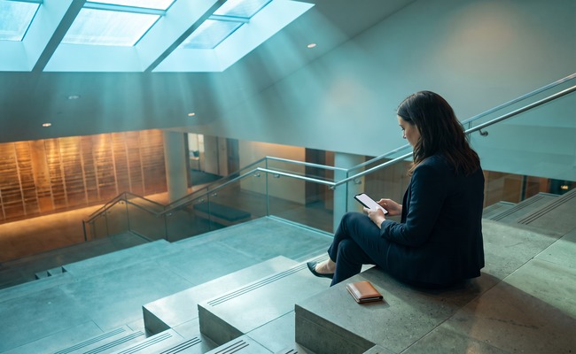 A person adult person separates a change credit card due date request from hardship questions on a blank phone in a modern atrium.