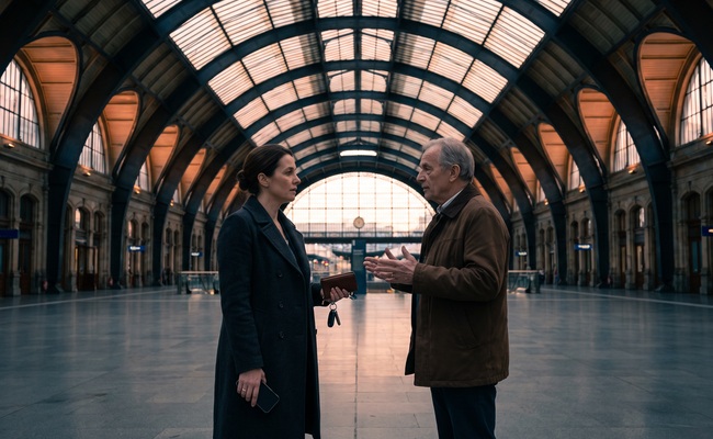 A person discusses how to resolve a missed personal loan payment with an adult adviser in a historic station concourse.