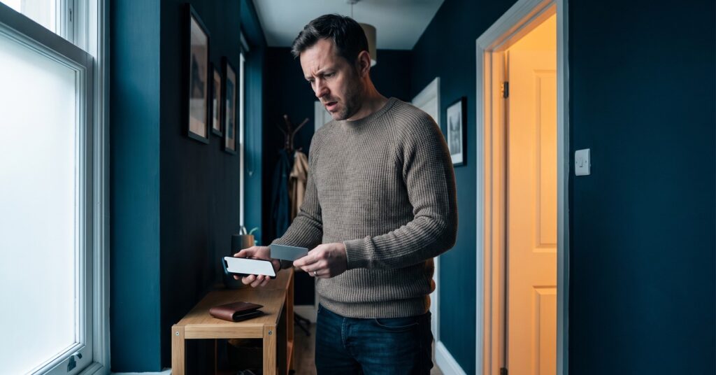 A person notices personal loan origination fees have reduced the cash delivered at a quiet apartment entryway.