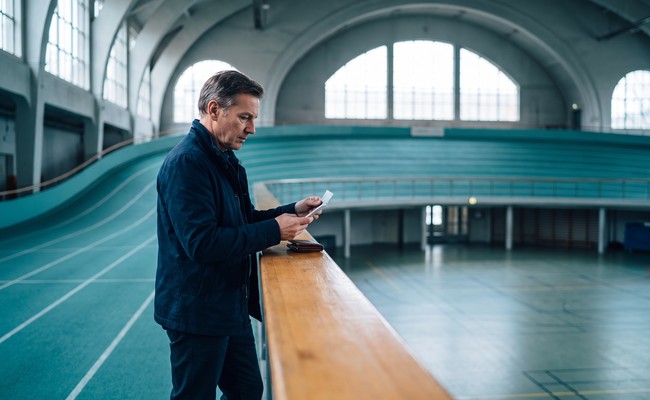 A person adult person reviews the contract language before deciding whether to pay off personal loan early at an indoor recreation track.