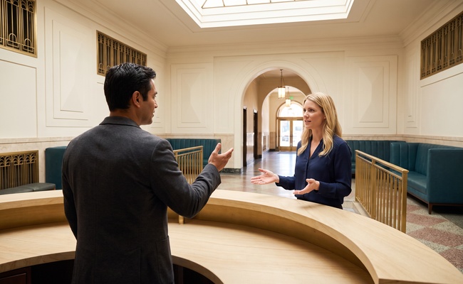 A person adult confirms the vehicle custodian with an attendant in a distinctive logistics-center lobby.