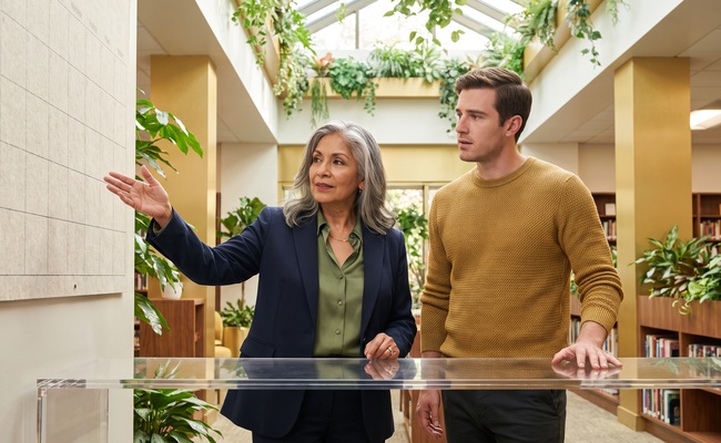 A person counselor supports an adult homeowner in a public library atrium.