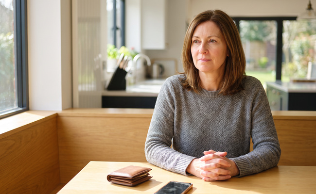 A person planning how to bring an account current at a bright dining nook