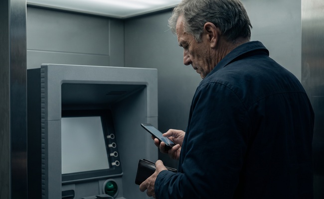 A person adult person reviews unbranded bank-account settings on a turned-away phone.