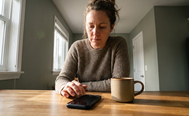 A person compares practical cash-flow options at an unbranded kitchen counter.