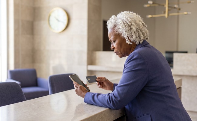 A person adult person reviewing a ChexSystems report with a turned-away phone in a neutral setting