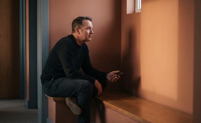 A person reviewing a ChexSystems report with a turned-away phone in a neutral setting