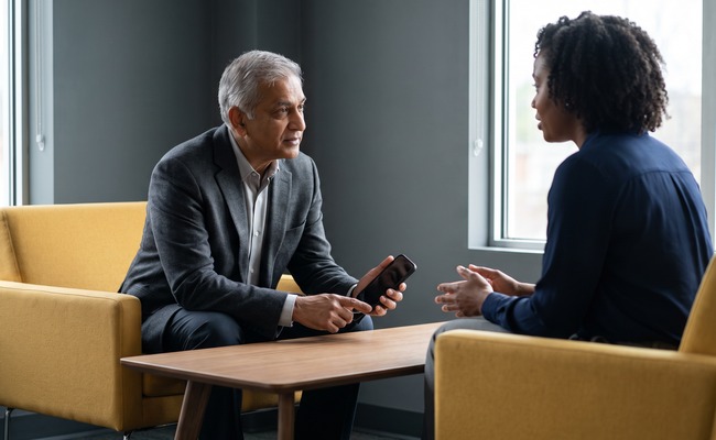 A person adult person reviewing a ChexSystems report with a turned-away phone in a neutral setting