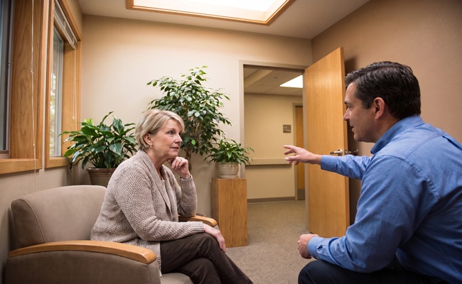 A person adult patient asks a hospital advocate about medical bill financial assistance.