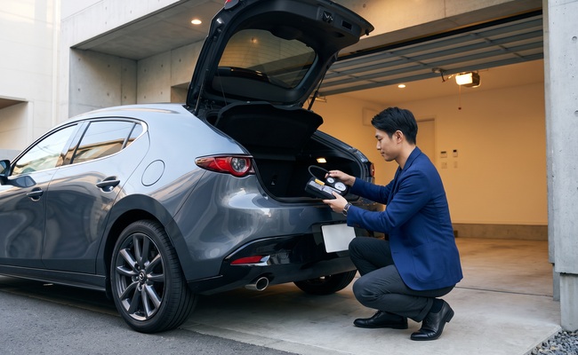 An adult checks a car’s roadside equipment before reviewing optional coverage.