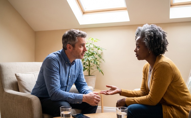 Two adults discuss the payment commitment required during student loan rehabilitation.