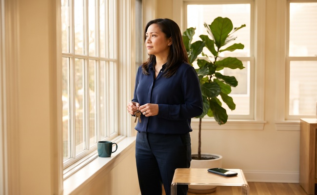 An adult woman holds keys and considers next steps in a tax lien versus tax levy matter.