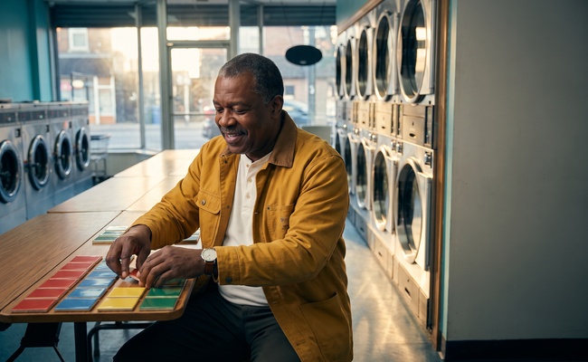 Person organizing payment dates at a laundromat counter.