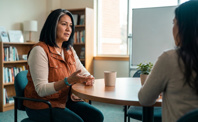Person discussing payment options with a support person at a community table.