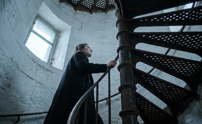 A woman climbing a narrow iron spiral stair inside a lighthouse, holding the rail, illustrating the steady step-by-step care that avoids the mistakes in this section.