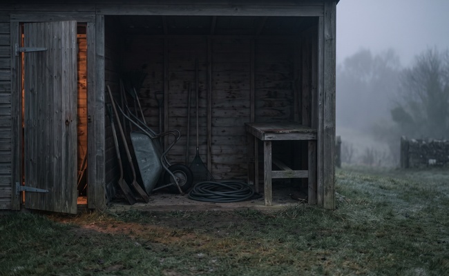 An open tool shed at dusk with no one inside, the empty place left when someone skips a judgment debtor examination.