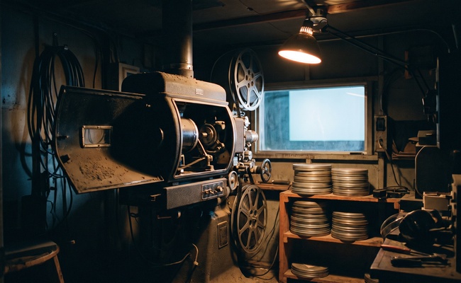 A projector throwing an image out of a dark booth, showing how answers to a post judgment discovery request travel beyond the page.