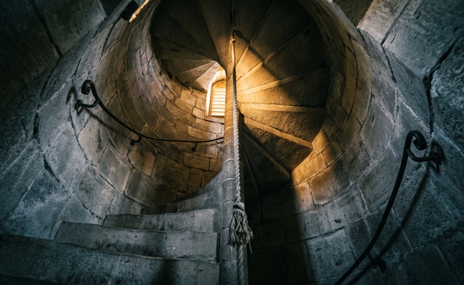 A stone bell tower stairwell climbing toward light, the way back after a post judgment discovery request mistake.