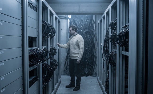 Equipment racks and coiled coaxial cable in a hilltop communications gallery at first light