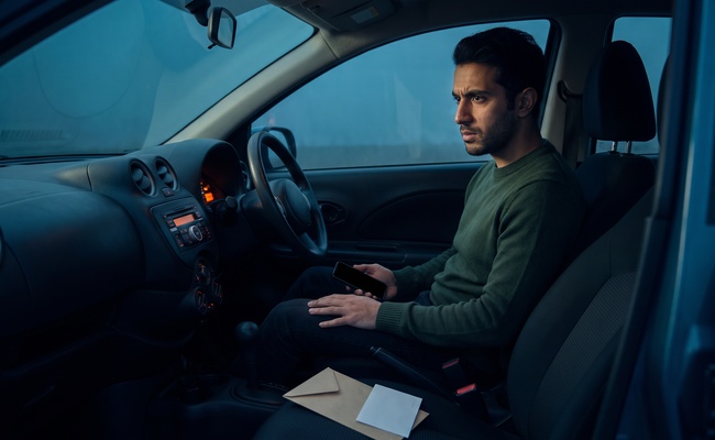 Person reviews a closed dispute packet in a parked car before challenging inaccurate account reporting.