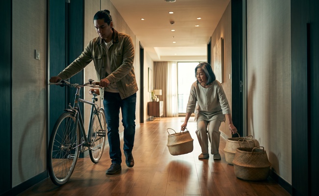 An adult pair keeps two household obligations visibly separate in a hallway.
